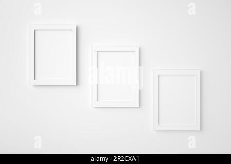 Drei leere oder leere rechteckige Bilderrahmen, die an die weiße Wand hängen. Hintergrundbild für Modellerstellung. 3D-Rendering. Stockfoto