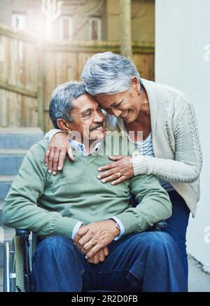 Behinderung, Rollstuhl und Seniorenpaar umarmen sich mit Fürsorge, Unterstützung und Liebe von älteren glücklichen Menschen im Ruhestand. Behinderte, Rehabilitation und alter Mann Stockfoto