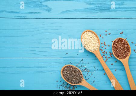 Gesundes Superfood: Sesam, Leinsamen und Chia auf Blau. Samen auf dem Löffel. Draufsicht Stockfoto