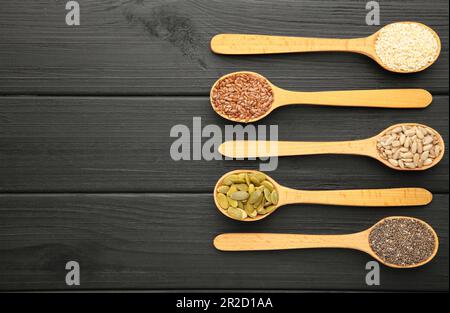 Gesundes Superfood: Sesam, Kürbiskerne, Sonnenblumenkerne, Leinsamen und Chia auf Schwarz. Draufsicht Stockfoto