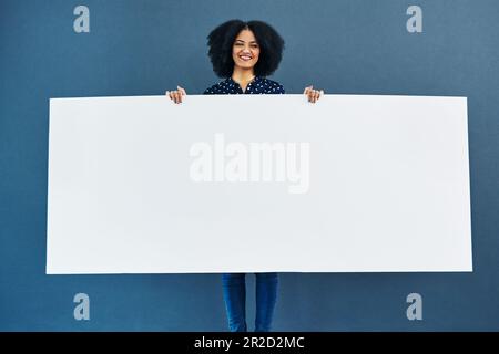 Raum, Poster und Porträt einer glücklichen Frau im Studio mit Banner für Nachrichten, soziale Medien oder Werbung auf blauem Hintergrund. Papier, Plakatwand und Frau Stockfoto