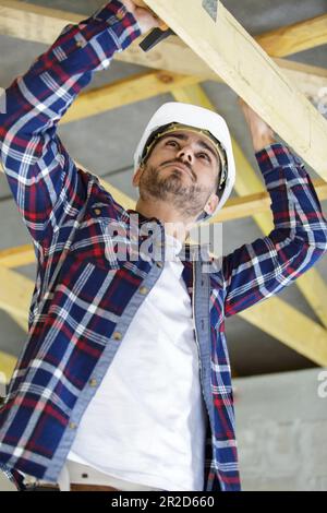 Junger Mann hält Bohrantrieb und Schrauben Stockfoto