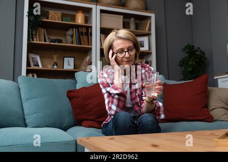 Nahaufnahme einer traurigen Seniorin mit Nackenschmerzen. Seniorin mit chronischem Schmerzsyndrom Fibromyalgie mit akuten Halsschmerzen. Weibliches Leiden für Stockfoto