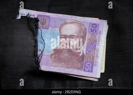 50 UAH liegen in einer Jeanstasche mit schwarzen Hosen, ukrainisches Geld Stockfoto