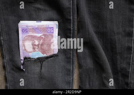 50 UAH liegen in einer Jeanstasche mit schwarzen Hosen, ukrainisches Geld Stockfoto