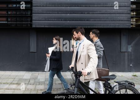 Junge Geschäftsleute Geschäftsmann und Geschäftsfrau gehen vom Bürogebäude zum Gebäude zwischen Meetings, wo sie Mitarbeiter zu besseren und besseren Schulen Stockfoto