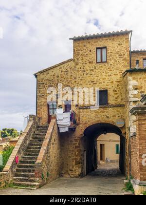 Die farbenfrohen mittelalterlichen Häuser und Gassen von San Quirico d'Orcia an einem sonnigen Frühlingstag Stockfoto