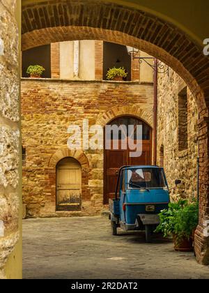 Ein alter Dreirad auf den gepflasterten Straßen von San Quirico d'Orcia Stockfoto