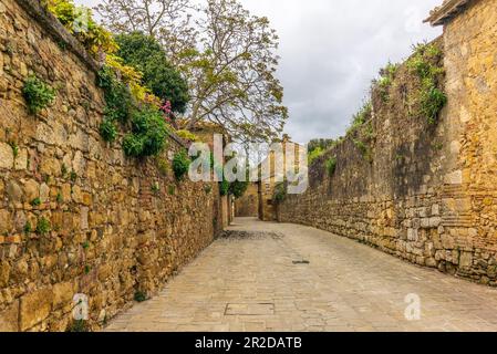 Die farbenfrohen mittelalterlichen Häuser und Gassen von San Quirico d'Orcia an einem sonnigen Frühlingstag Stockfoto