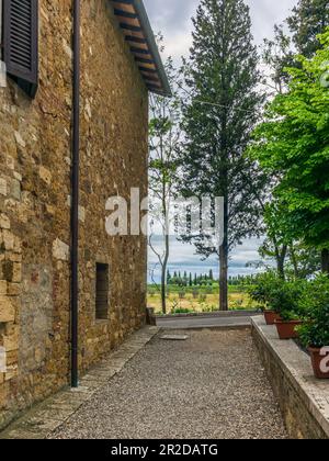 Die farbenfrohen mittelalterlichen Häuser und Gassen von San Quirico d'Orcia an einem sonnigen Frühlingstag Stockfoto