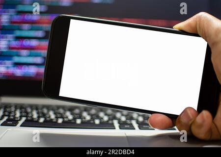 Der Entwickler möchte eine App auf dem Smartphone-Gerät ausführen, nachdem er über die IDE, das handgehaltene Smartphone-Gerät, den weißen Bildschirm „Take a clos“ codiert hat Stockfoto