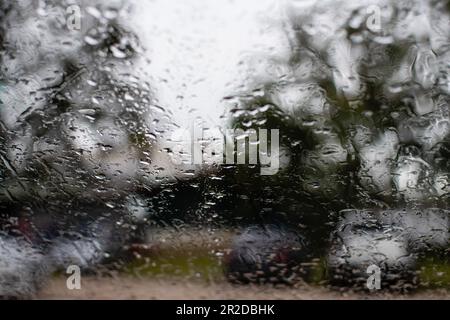 Helles Wasser auf dem Autofenster, nach Regenabend, auf dem Parkplatz, machen Sie Nahaufnahmen, Farbe schwarz und grau Hintergrund verschwommen und Landschaft. Stockfoto