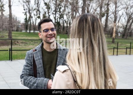 Junge Geschäftsleute Geschäftsmann und Geschäftsfrau gehen vom Bürogebäude zum Gebäude zwischen Meetings, wo sie Mitarbeiter zu besseren und besseren Schulen Stockfoto