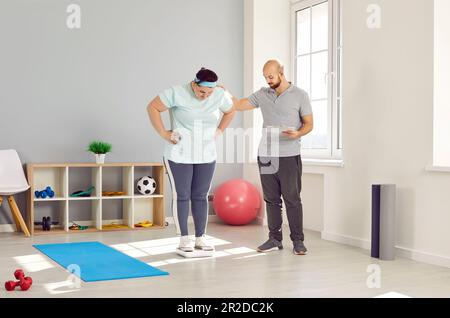 Personal Trainer zur Beurteilung der Gesundheit übergewichtiger junger Frauen Stockfoto
