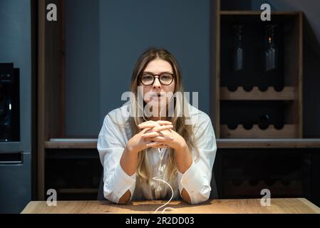 Bewerbungsgespräch mit einer jungen freiberuflichen Geschäftsfrau per Videoanruf von zu Hause aus mit dem Unternehmen, auf dessen Anzeige sie geantwortet hat. Junge, arbeitende Frau benutzt Laptop Stockfoto