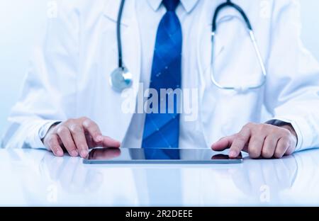 Professioneller Arzt Mann trägt eine Uniform mit einem Gerätetablett des Krankenhauses. Doctor Touchscreen Tablet für medizinische Versorgung und Behandlung entfernt von innen Stockfoto