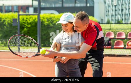 Aktive Familie spielt Tennis auf dem Platz Stockfoto