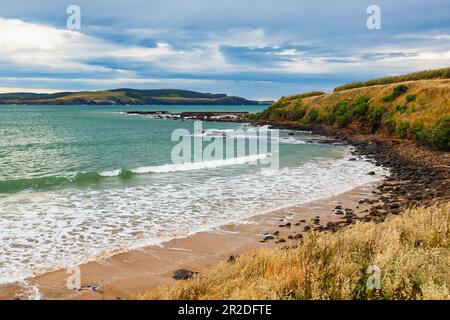 Der Porpoise Bay Beach im Southland District von South Island, Neuseeland, wird von Wellen gespült Stockfoto