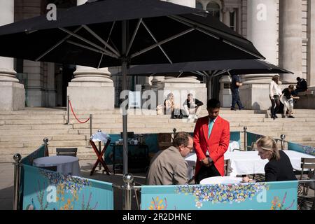 Ein Kellner bedient die Gäste am 18. Mai 2023 in London, England, in der Bar Fortnum & Mason außerhalb der Royal Exchange in der City of London, dem Finanzviertel der Hauptstadt. Stockfoto