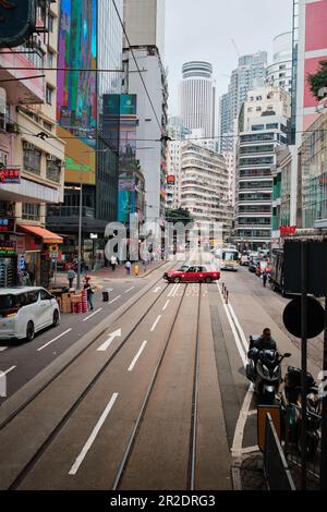 Hongkong, China - April 10 2023: Rotes Taxi von Hongkong und Hochhäuser von Causeway Bay Stockfoto