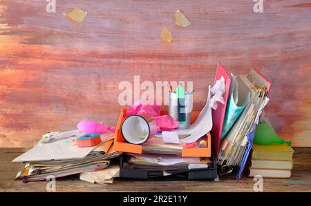 Unordentlicher Arbeitsplatz, chaotisches Büro, überarbeitetes Konzept mit schäbigem Schreibtisch, verschiedene Büromaterialien, kostenloser Kopierbereich Stockfoto
