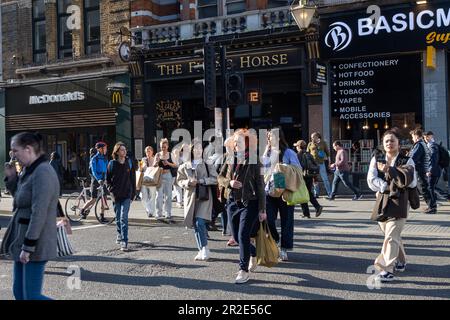 London, Vereinigtes Königreich - April 2023: Geschäftige Kreuzung mit Fußgängern, Touristen und Autos vor der Tottenham Court Road Station, Central London, UK Stockfoto