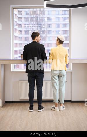 Ein Paar, das am Arbeitsplatz in der Nähe des Fensters an einem Projekt arbeitet Stockfoto