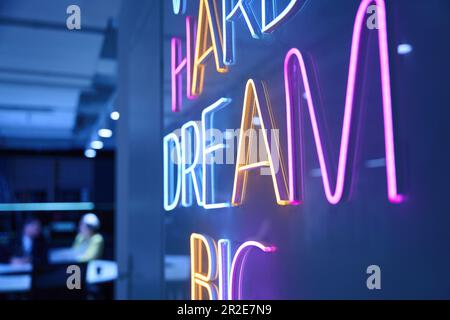 Fluoreszierende Schilder an der Wand im Büro Stockfoto