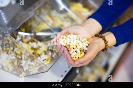 Eine Handvoll nahrhafter knochenförmiger Hundesnacks in weiblichen Händen Stockfoto