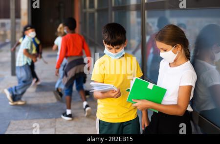 Die Schule tweens in medizinischen Masken auf dem Schulhof während der Pause Stockfoto