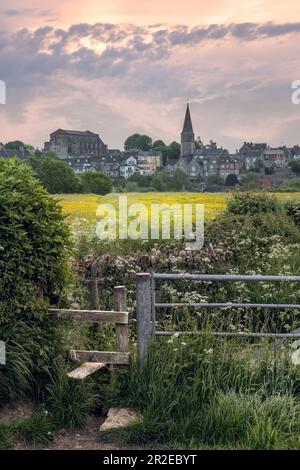 Malmesbury, Wiltshire, England - die nächtliche Wolke wird bei Sonnenaufgang langsam aufklaren, wenn die Sonne über der historischen Abtei in der hügeligen Stadt Malmesbur aufgeht Stockfoto