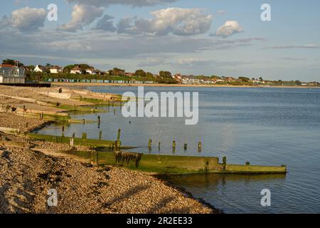 Ein ruhiges Meer mit Blick über das Meer in Richtung Salterns Beach, Hampshire. England im Frühling. Stockfoto