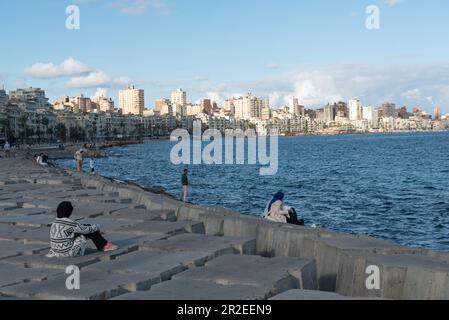 Alexandria, Ägypten. 04. Dezember 2022. Die Menschen sitzen auf Betonblöcken, die als Verteidigung gegen den steigenden Meeresspiegel des Mittelmeers entlang der Corniche von Alexandria, der zweitgrößten Stadt Ägyptens, positioniert sind. (Foto: John Wreford/SOPA Images/Sipa USA) Guthaben: SIPA USA/Alamy Live News Stockfoto