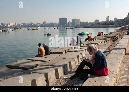 Alexandria, Ägypten. 01. Dezember 2022. Die Menschen sitzen auf Betonblöcken, die als Verteidigung gegen den steigenden Meeresspiegel entlang der Corniche von Alexandria positioniert sind, der zweitgrößten Stadt Ägyptens. (Foto: John Wreford/SOPA Images/Sipa USA) Guthaben: SIPA USA/Alamy Live News Stockfoto