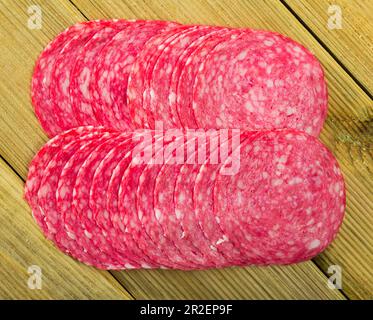 Salami-Scheiben auf Holzhintergrund Stockfoto