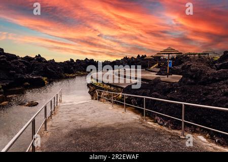 Natürliche Pools in Biscoitos während eines dramatischen Sonnenuntergangs an der Küste der Insel Terceira, Azoren, Portugal Stockfoto