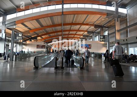 Reisende gehen durch den langen Flur zwischen den Toren im Terminal 2 des Raleigh-Durham International Airport in Raleigh, North Carolina. Stockfoto