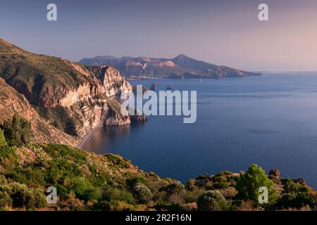 Lipari Küste mit Blick auf Vulcano Vulkaninsel bei Sonnenuntergang, Sizilien Italien Stockfoto