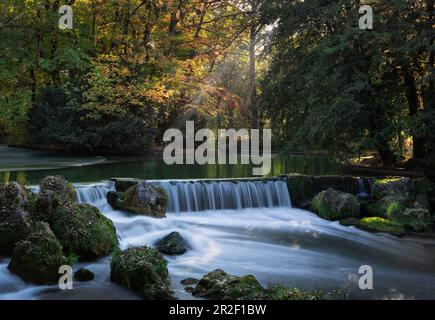 Wasserfall am Schwabinger Bach im Englischen Garten im Herbst am Nachmittag in München, Bayern Stockfoto