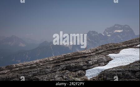 Frauen wandern über Felsen, Berge der Dolomiten im Hintergrund, mit Schneefelder, Cinque Torri Südtirol Stockfoto