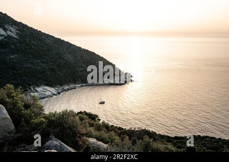 Segelboot bei Sonnenuntergang in einer Bucht in der Nähe von Calvi, Korsika, Frankreich. Stockfoto