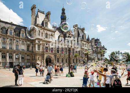 Kinder spielen mit Seifenblasen vor dem Hotel De Ville, dem größten Rathaus Europas, dem Hotel De Ville, Paris, Frankreich, Europa Stockfoto