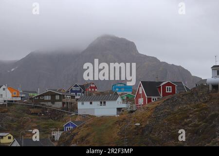 Sisimiut in Westgrönland; zweitgrößte Stadt Grönlands; Stadtbild; farbenfrohe Holzhäuser in felsigem, hügeligem Gelände; überirdische Wasserrohre supp Stockfoto