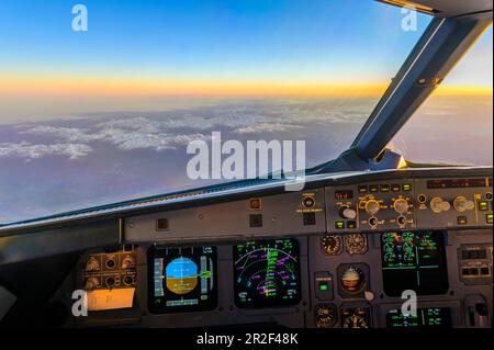 Sonnenaufgang im Cockpit eines Airbus über den Alpen Stockfoto