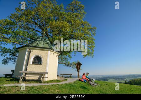 Frau und Mann radeln in der Kapelle, Samerberg, Chiemgau, Chiemgau Alpen, Oberbayern, Bayern, Deutschland Stockfoto