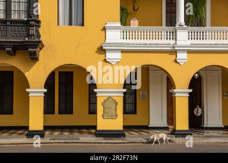 Ein Hund schleicht sich vorbei an einem atemberaubenden Kolonialpalast auf dem zentralen Platz (Plaza Mejor) in der Innenstadt, von Lima, Lima, Peru, Südamerika Stockfoto