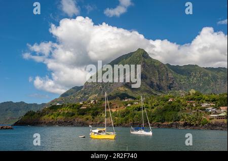 Zwei Segelboote liegen in der Sonne vor einem riesigen Berg, Atuona, Hiva OA, Marquesas-Inseln, Französisch-Polynesien, Südpazifik Stockfoto