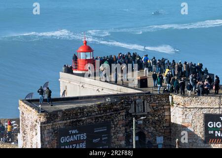 Europa, Portugal, Region Oeste, Nazaré, Zuschauer, die während einer Veranstaltung im Januar 2022 auf riesigen Wellen in der Nähe von Praia do Norte reiten Stockfoto