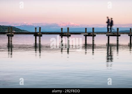 Blick auf eine Anlegestelle am Starnberger See bei Sonnenuntergang, im Hintergrund die Alpen, Starnberg, Bayern, Europa Stockfoto