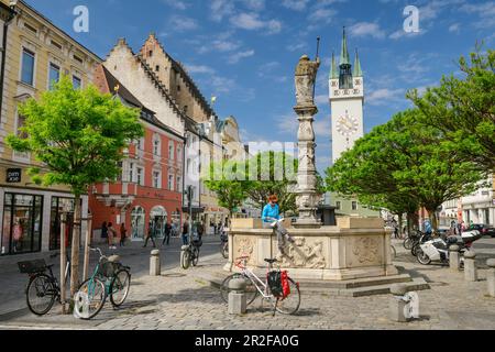 Frau, die am Brunnen sitzt und liest, Straubing, Straubing, Donau-Radweg, Niederbayern, Bayern, Deutschland Stockfoto